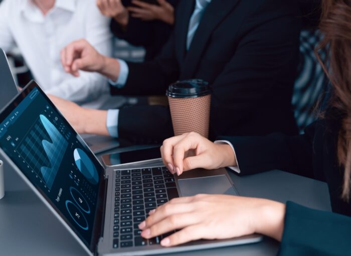 Closeup to view hand using laptop to analyze financial data in harmony office. Business team analyze business analytic or business intelligence dashboard on laptop screen show graph and chart with statistic in harmony office. Analyst team meeting researching, planning strategy.