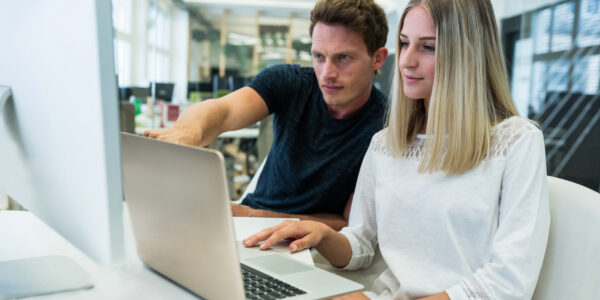 Male and female graphic designers interacting with each other in office